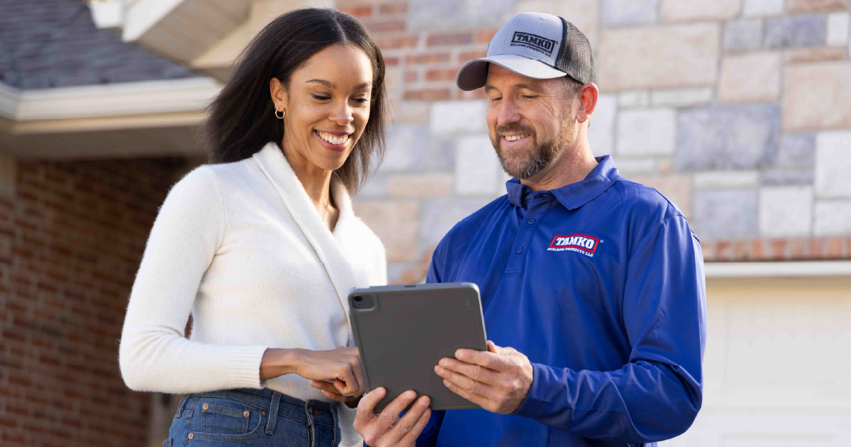 Tamko contractor signing paperwork with a customer